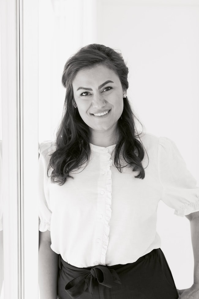Black and white portrait of Dr. Behnaz (Bennie) Yavari beside a window.