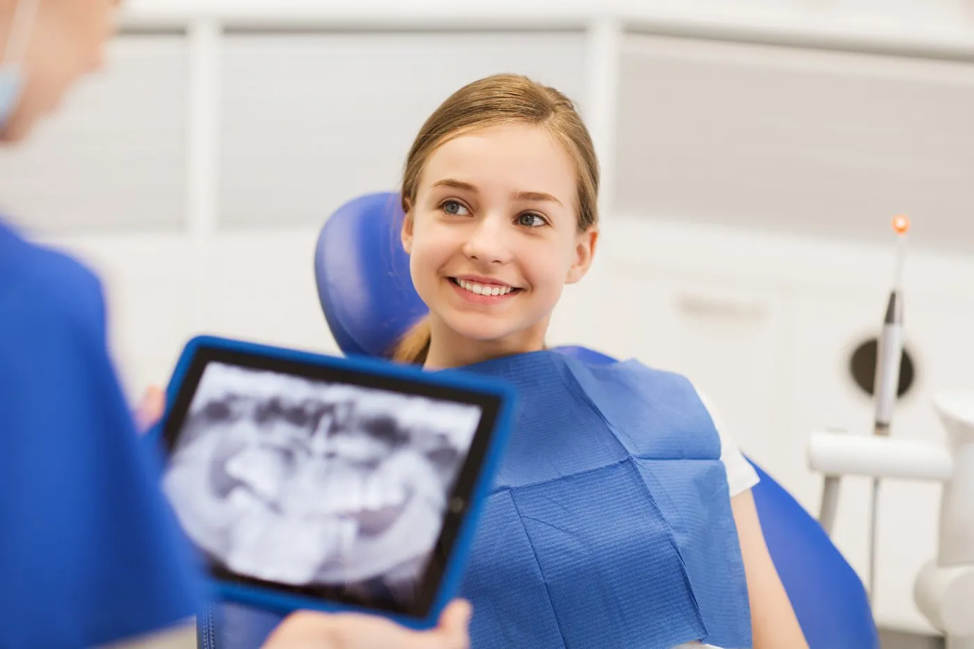 A teenage girl smiling while sitting in an exam chair