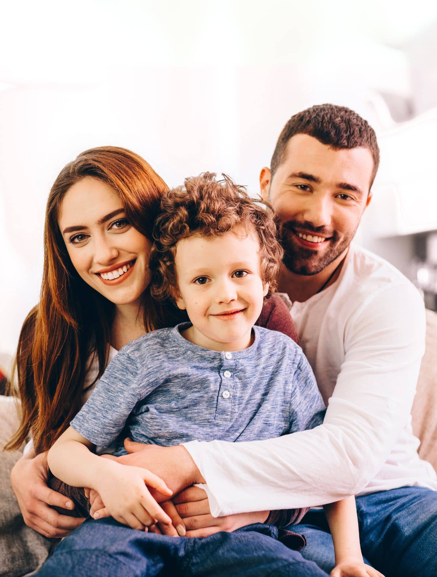 Parents and their young son smiling together after an orthodontic visit.
